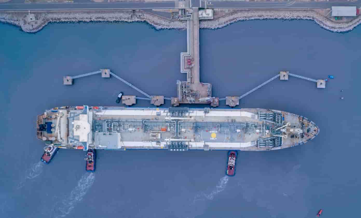 Aerial view of a floating storage and regasification vessel moored at an LNG terminal.