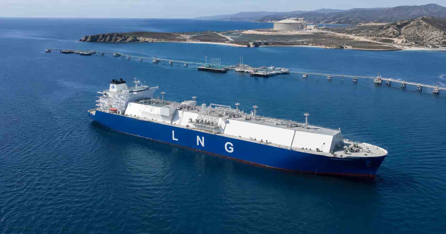 An LNG carrier approaching a coastal floating terminal.