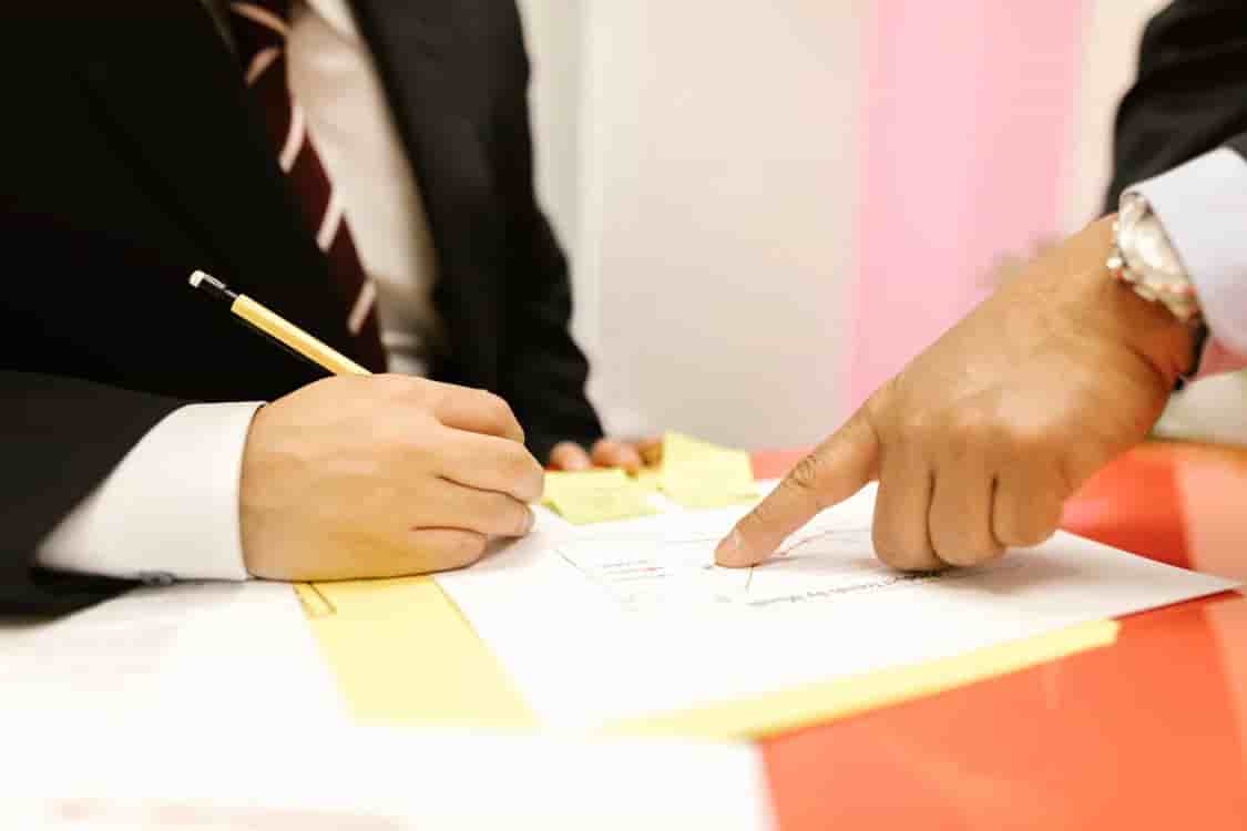Colleagues reviewing and signing committee documents.